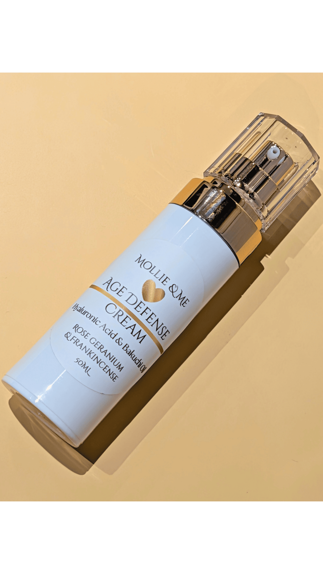 Mollie & Me Age Defense Cream bottle on a beige background