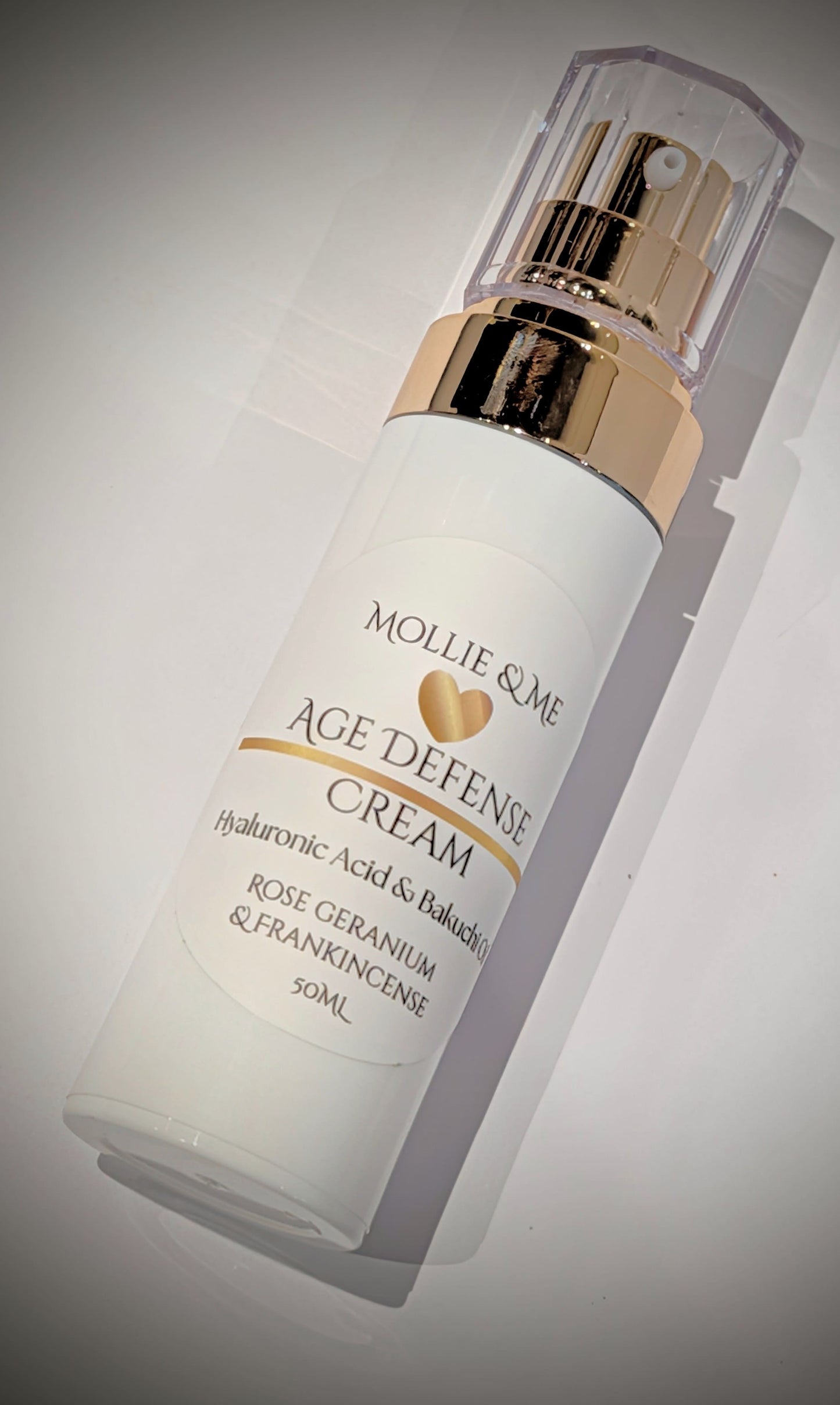 Mollie & Me Age Defense Cream bottle on a gray background 