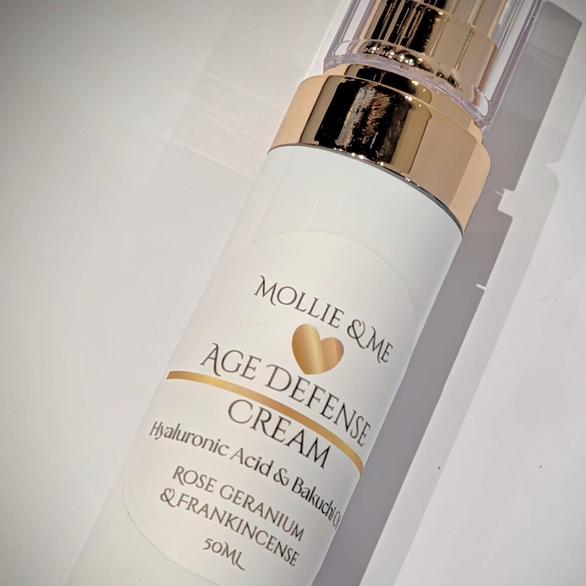 Mollie & Me Age Defense Cream bottle on a gray background 