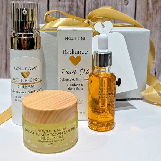 Skincare products including a cream, facial oil, and gel cleanser with 'Mollie & Me' branding on a wooden background.