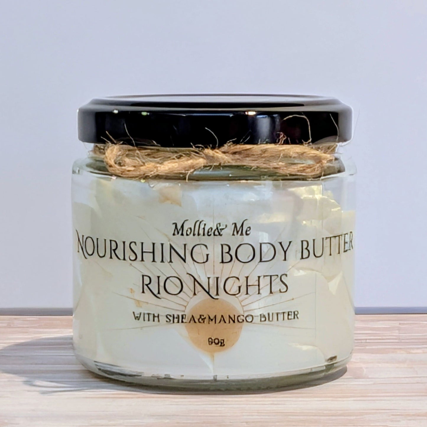 Jar of Mollie & Me Nourishing Body Butter with 'Rio Nights' flavor on a wooden surface.