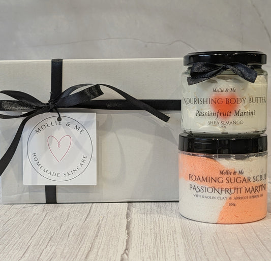 A pamper skincare giftset by Mollie & Me handmade skincare, featuring an sls and paraben free sugar scrub and a Shea body butter in a white gift box with black ribbon and a gift tag.