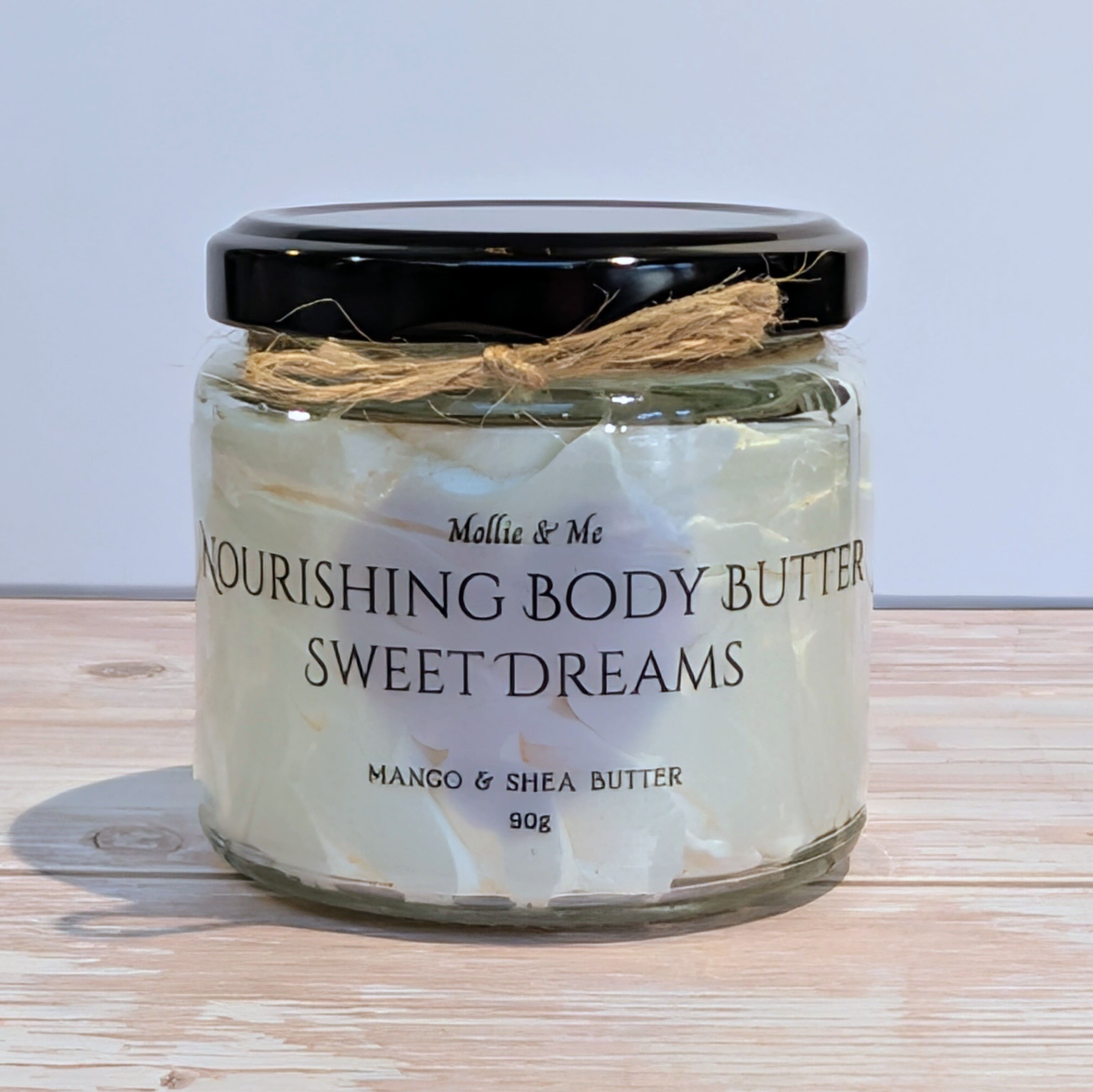 Jar of 'Sweet Dreams' nourishing body butter with a black lid on a wooden surface.